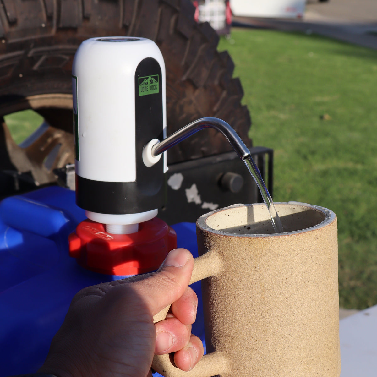Reliance Aqua-Tainer water pump adapter kit dispensing water in a cup
